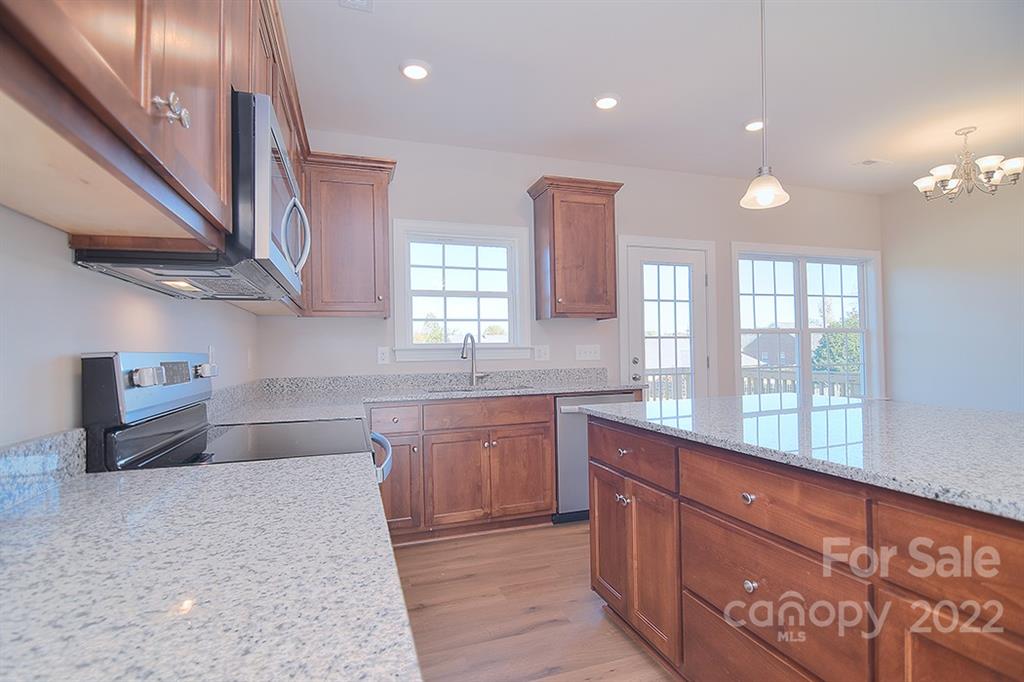 288 Ella Drive, Unit 101 Locust, NC 28097 - Photo 13 of 28 a large kitchen with stainless steel appliances granite countertop a large stove a sink and a refrigerator