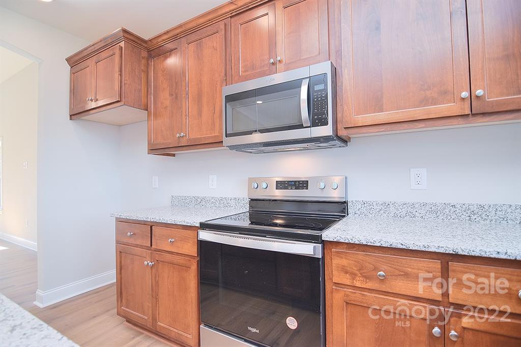 288 Ella Drive, Unit 101 Locust, NC 28097 - Photo 15 of 28 a kitchen with stainless steel appliances granite countertop white cabinets and a stove top oven