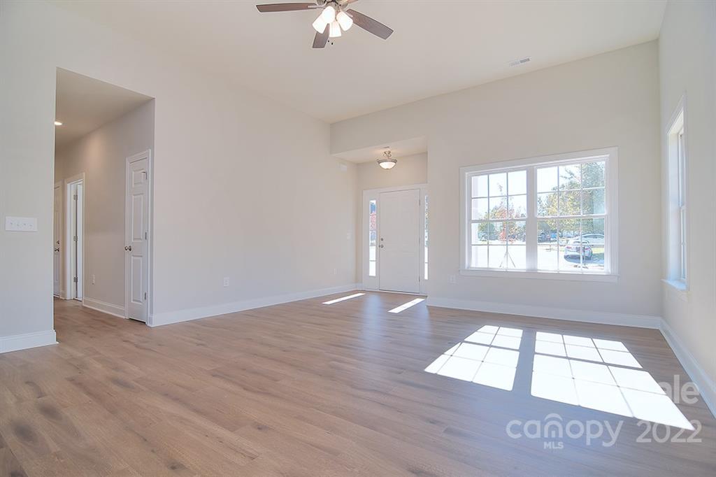 288 Ella Drive, Unit 101 Locust, NC 28097 - Photo 7 of 28 an empty room with wooden floor and windows
