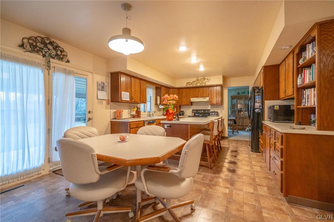 1540 Hidden Valley Road Allentown, PA 18103 - Photo 15 of 42 a dining room with furniture a kitchen view and a chandelier