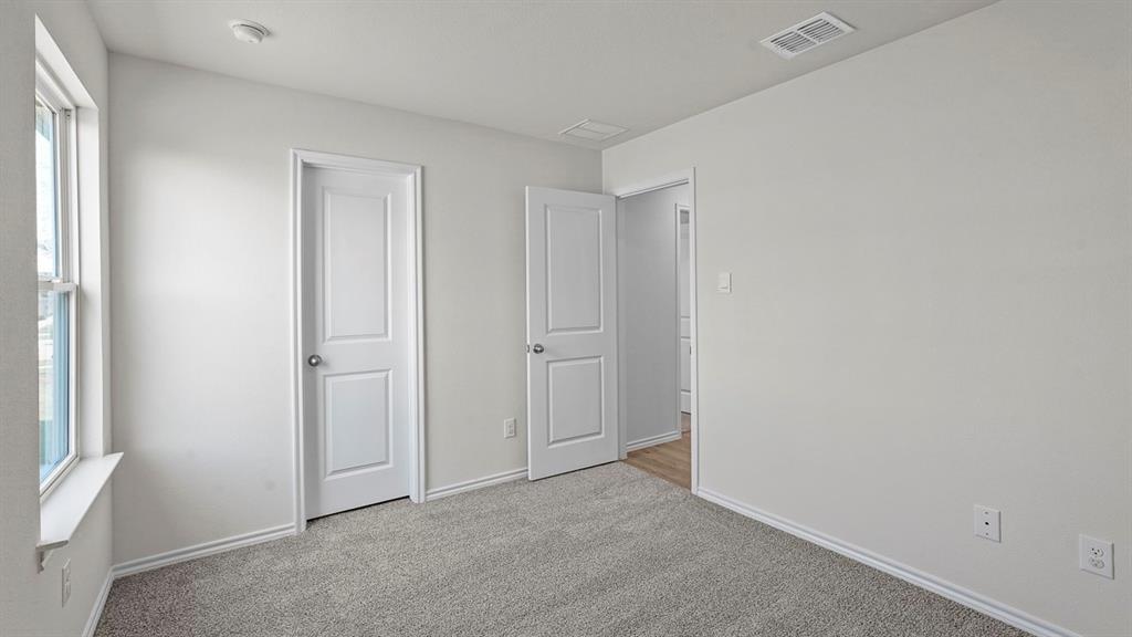 1675 Mantle Road Crandall, TX 75114 - Photo 24 of 27 Light gray carpeted room with white walls, baseboards, and window trim