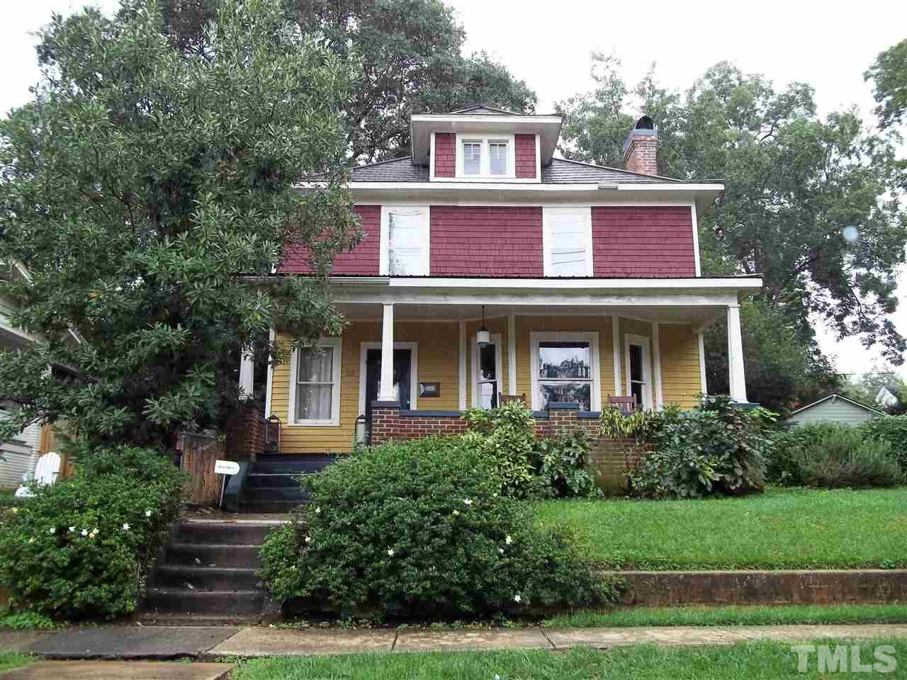 a front view of a house with trees and garage