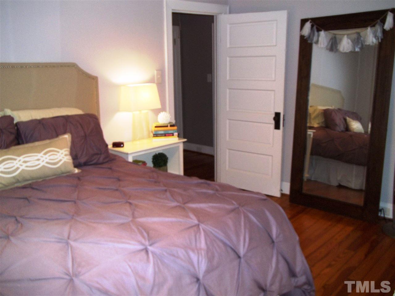 507 Cleveland Street Raleigh, NC 27605 - Photo 17 of 25 a bedroom with a bed and a mirror