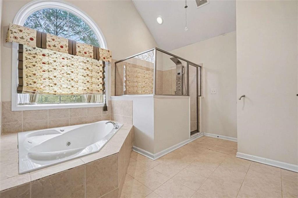 3183 Gus Robinson Road Powder Springs, GA 30127 - Photo 16 of 27 a bathroom with a bathtub and a shower