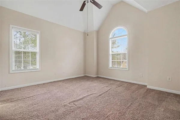 an empty room with windows and fan