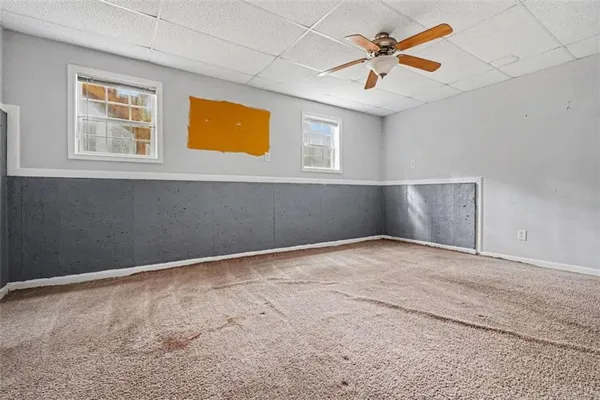 an empty room with windows and fan