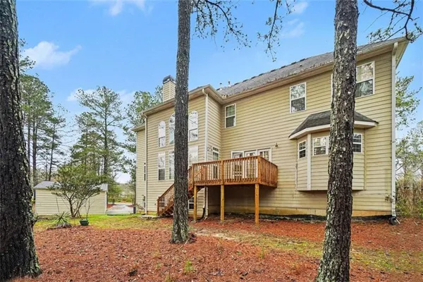a view of house with a yard and wooden fence