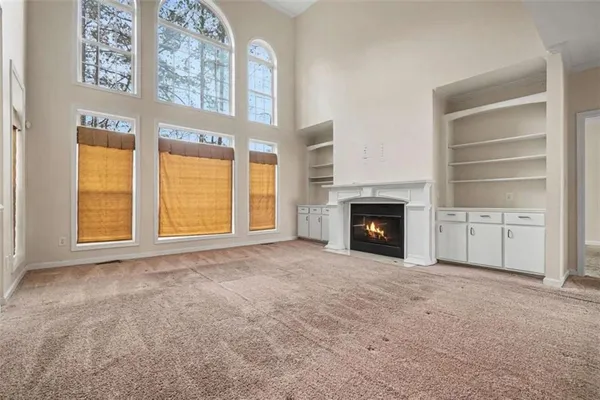 a view of an empty room with a fireplace and a window