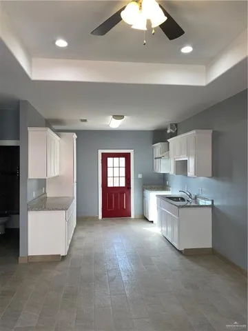 a large white kitchen with a white countertops and fireplace
