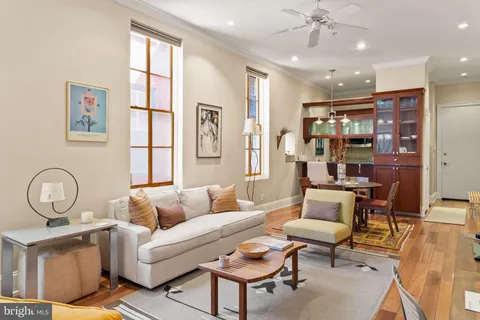 a living room with furniture a chandelier and a dining table