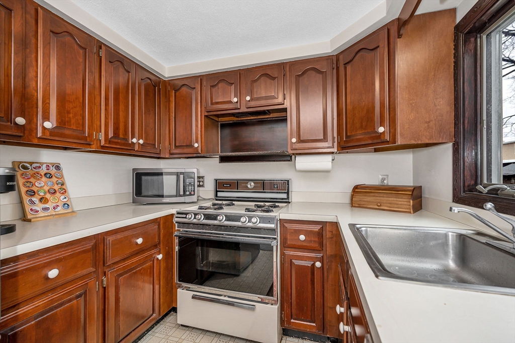 9 Allen Road Waltham, MA 02453 - Photo 13 of 40 a kitchen with granite countertop a sink a stove and cabinets