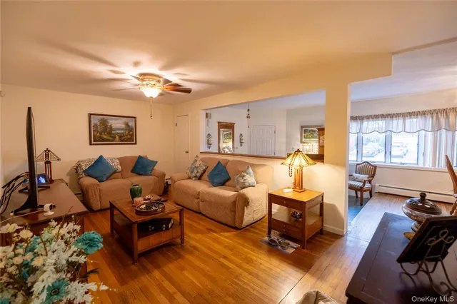 a living room with furniture a large window and a wooden floor