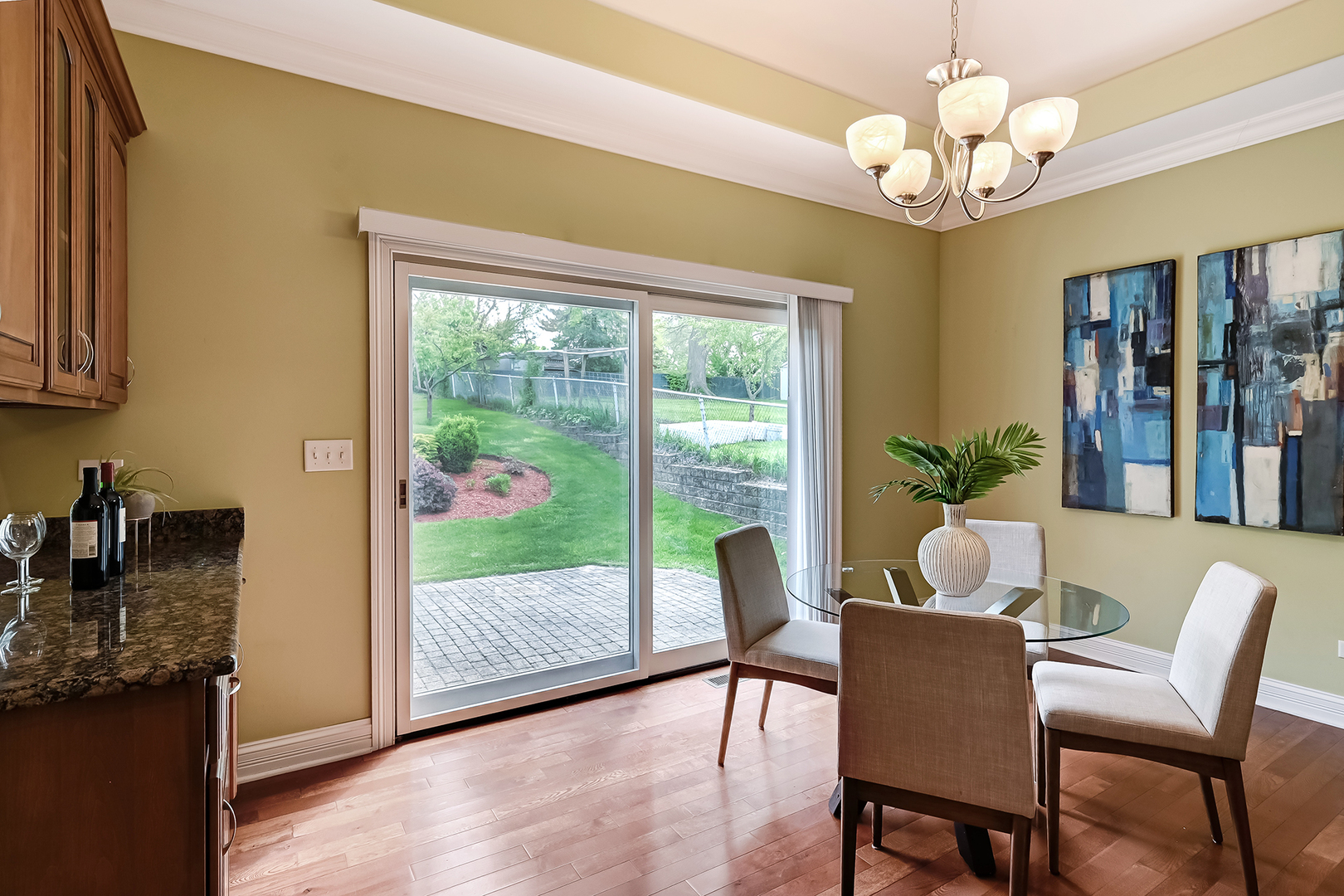 8827 Palisades Road Burr Ridge, IL 60527 - Photo 12 of 35 a dining room with wooden floor a chandelier a glass table and chairs