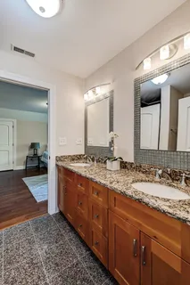 a spacious bathroom with a granite countertop sink and a mirror