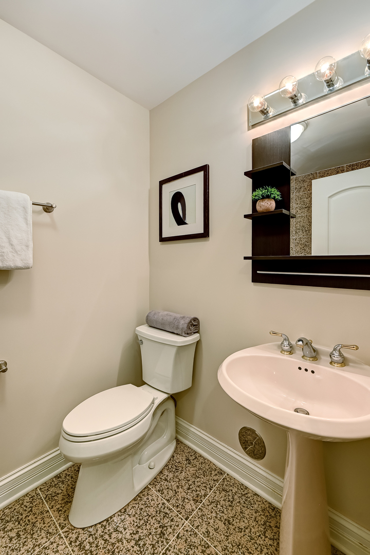 8827 Palisades Road Burr Ridge, IL 60527 - Photo 29 of 35 a bathroom with a toilet sink and mirror