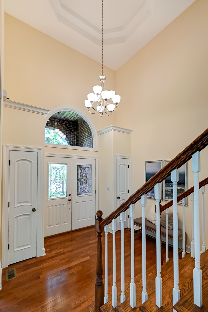 8827 Palisades Road Burr Ridge, IL 60527 - Photo 4 of 35 a view of a room with wooden floor and chandelier