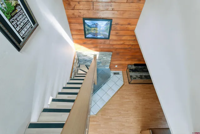 a hallway with stairs and wooden floor