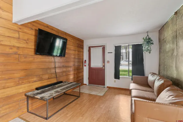 a living room with furniture a flat screen tv and a floor to ceiling window