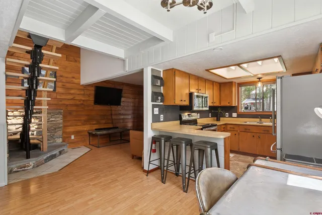 a kitchen with a table chairs refrigerator and cabinets