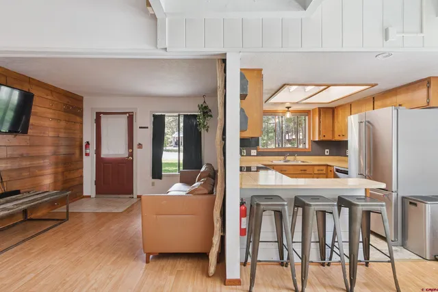 a view of a kitchen with furniture and wooden floor