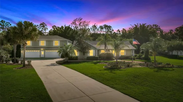 a front view of a house with a yard and tree s