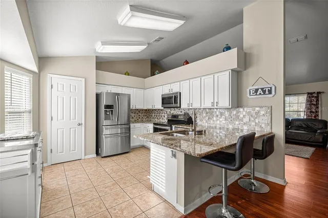 a kitchen with cabinets and chairs