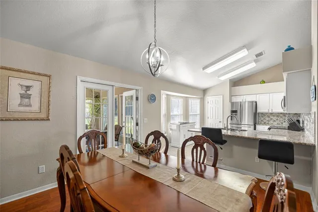 a dining room with furniture a chandelier and wooden floor