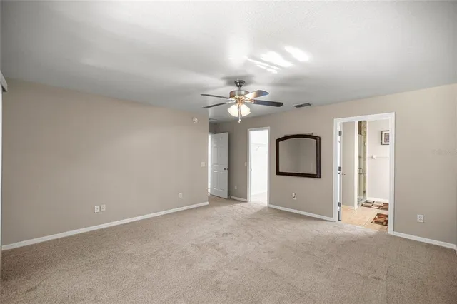 a view of a room with a ceiling fan and window