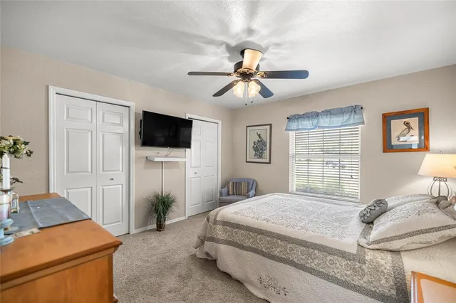 a bedroom with a bed a tv and wooden floor