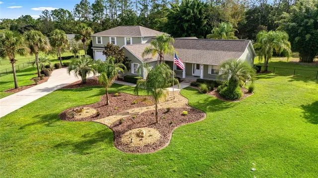 a aerial view of a house with yard and green space