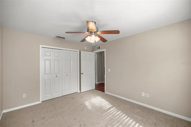 a view of a room with a ceiling fan and a window