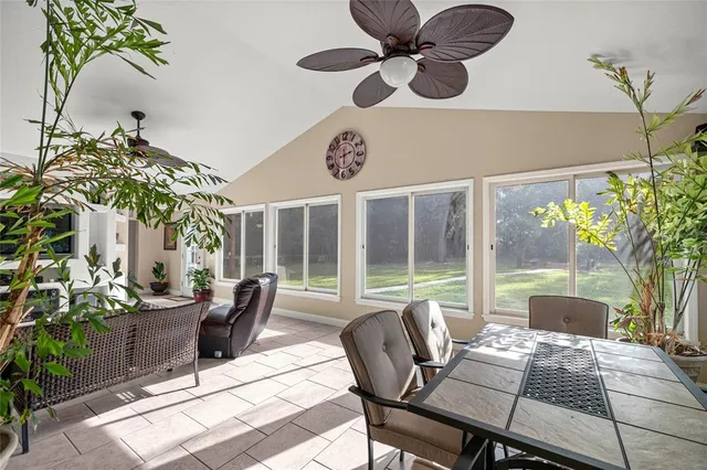 a dining room with furniture potted plants and wooden floor