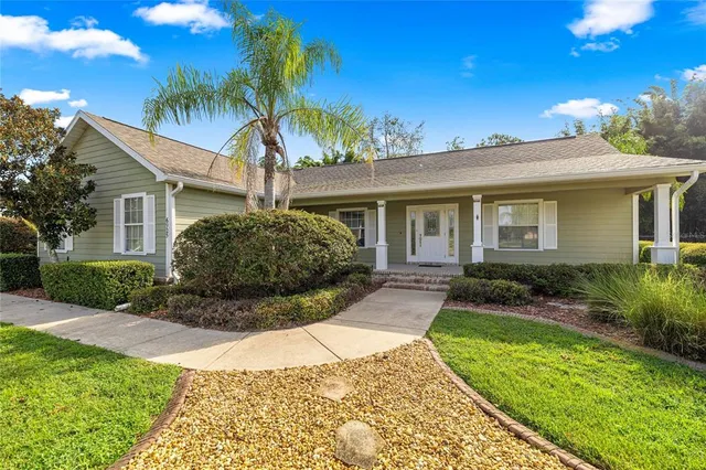 a view of a house with a yard and potted plants