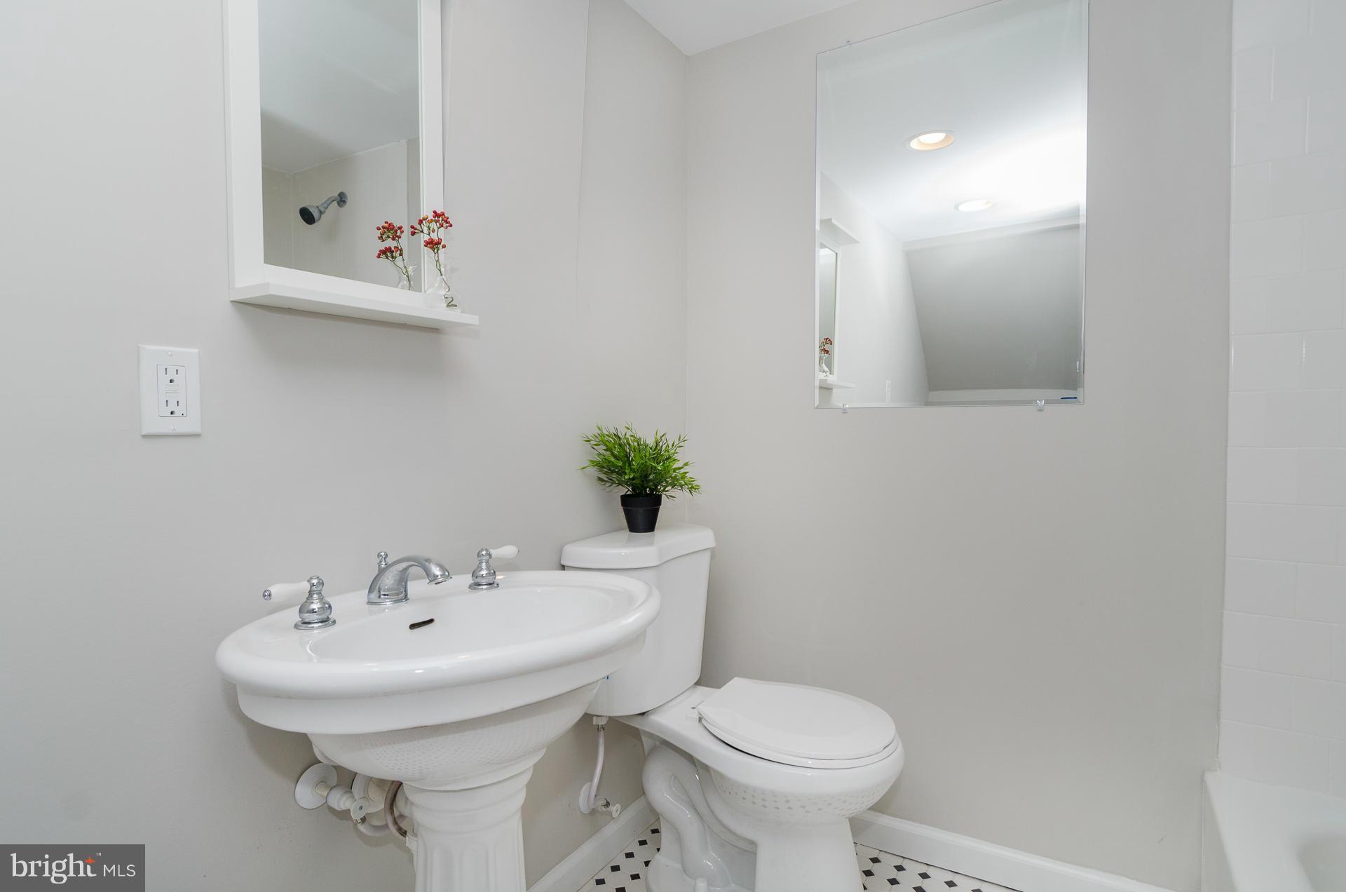 1033 Downton Road Baltimore, MD 21227 - Photo 22 of 27 a bathroom with a sink a toilet and mirror