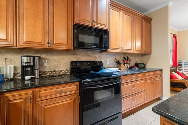 a kitchen with stainless steel appliances granite countertop a stove a sink and a microwave