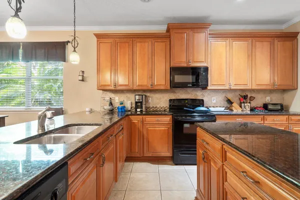 a kitchen with granite countertop a stove sink and cabinets