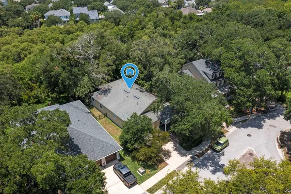 an aerial view of a residential houses with outdoor space and trees