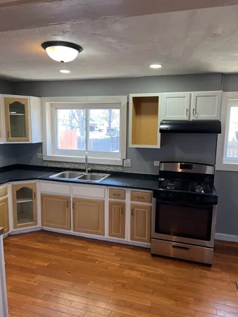 a kitchen with stainless steel appliances granite countertop a stove a sink and a microwave