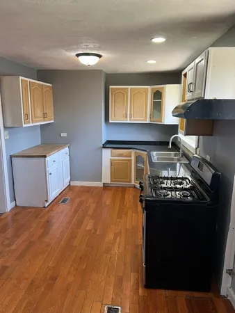 a kitchen with a stove and a wooden cabinets