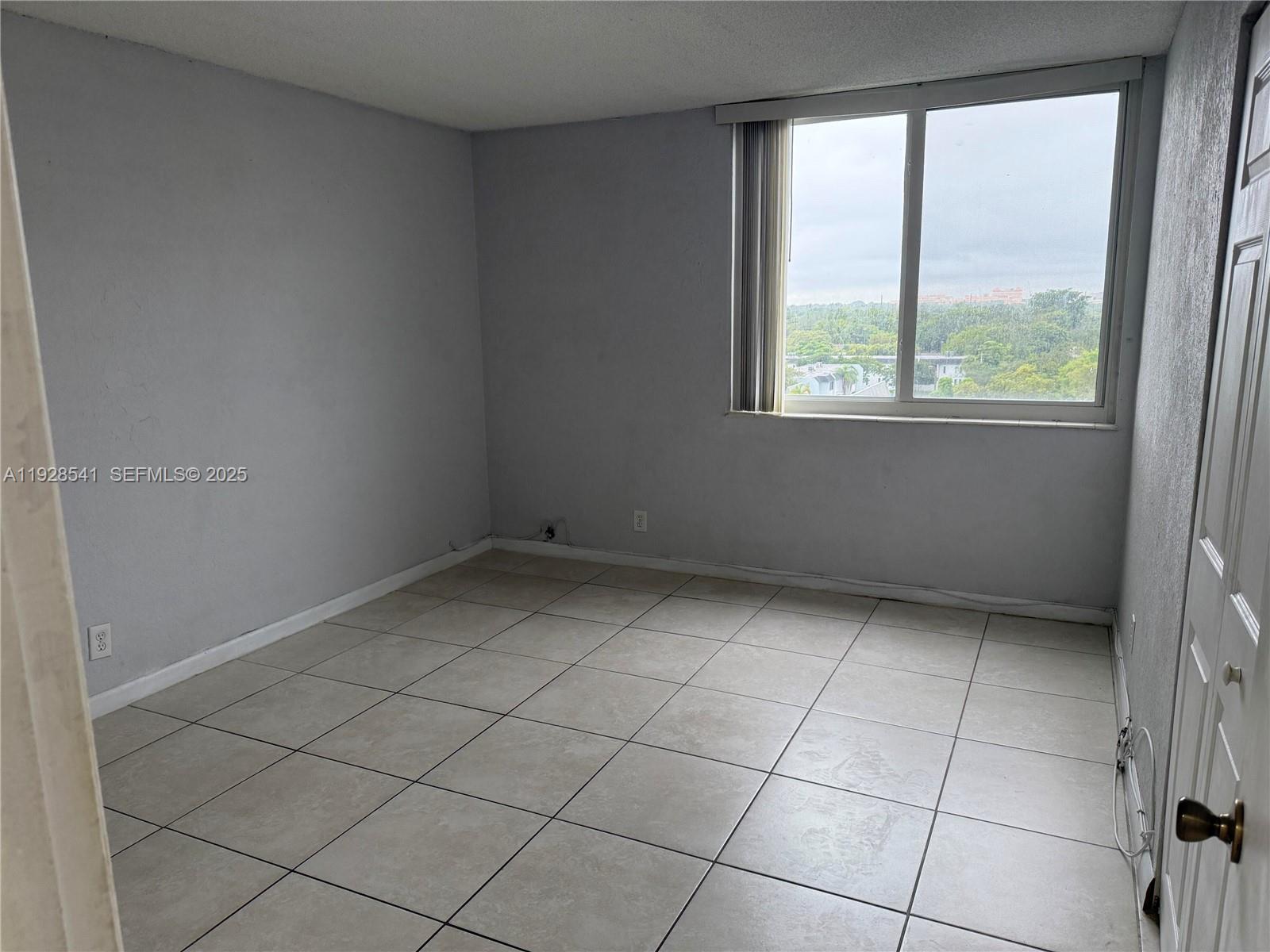 9001 Southwest 77th Avenue, Unit C709 Miami, FL 33156 - Photo 6 of 17 an empty room with a window