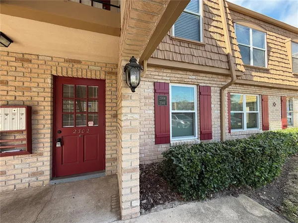 a view of a brick house with large windows