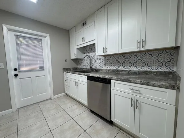 a kitchen with stainless steel appliances granite countertop a refrigerator stove a sink and dishwasher