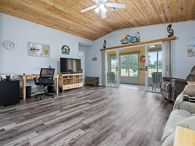 a living room with furniture wooden floor and flat screen tv
