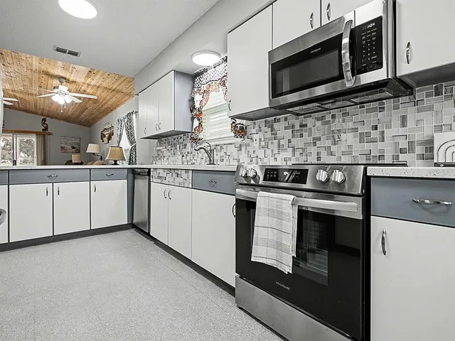 a kitchen with stainless steel appliances granite countertop a stove microwave and sink