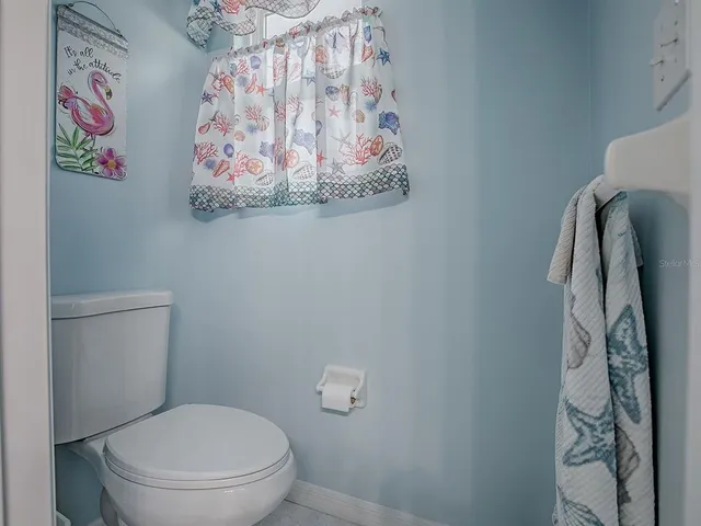 a white toilet sitting next to a shower curtain