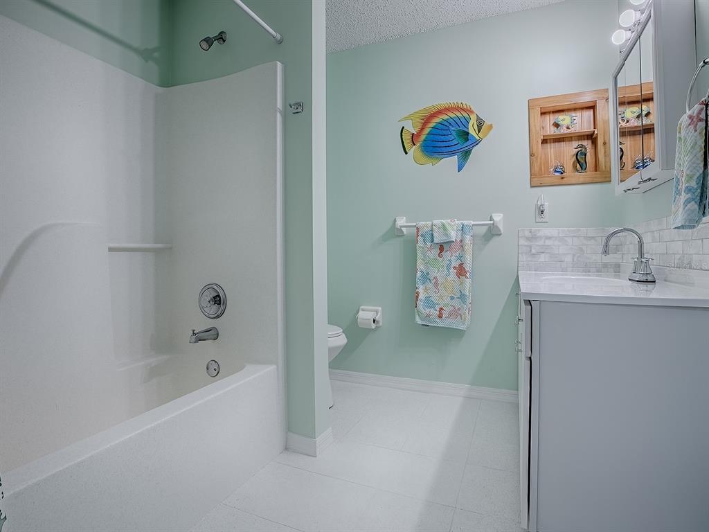 634 Timbercrest Drive Leesburg, FL 34748 - Photo 30 of 38 a bathroom with a bathtub sink and mirror