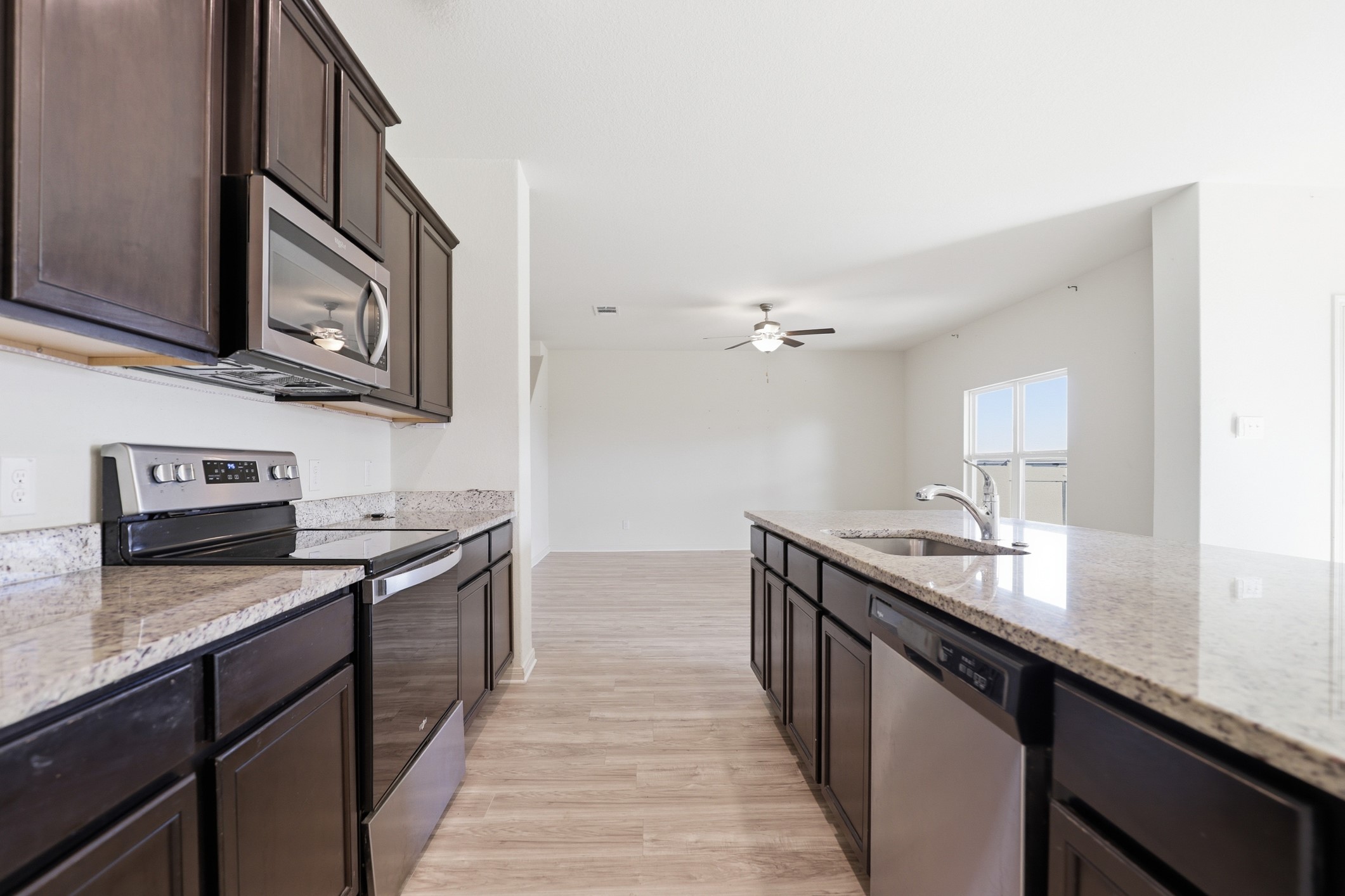 300 Hyacinth Way Jarrell, TX 76537 - Photo 11 of 30 a kitchen with stainless steel appliances granite countertop a sink stove oven and wooden cabinets