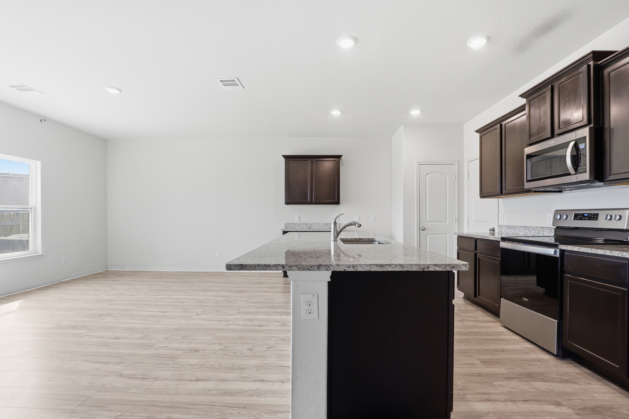 300 Hyacinth Way Jarrell, TX 76537 - Photo 10 of 30 a kitchen with stainless steel appliances granite countertop a sink and a stove top oven with wooden floor