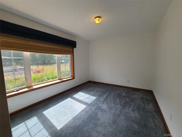 an empty room with windows and cabinet