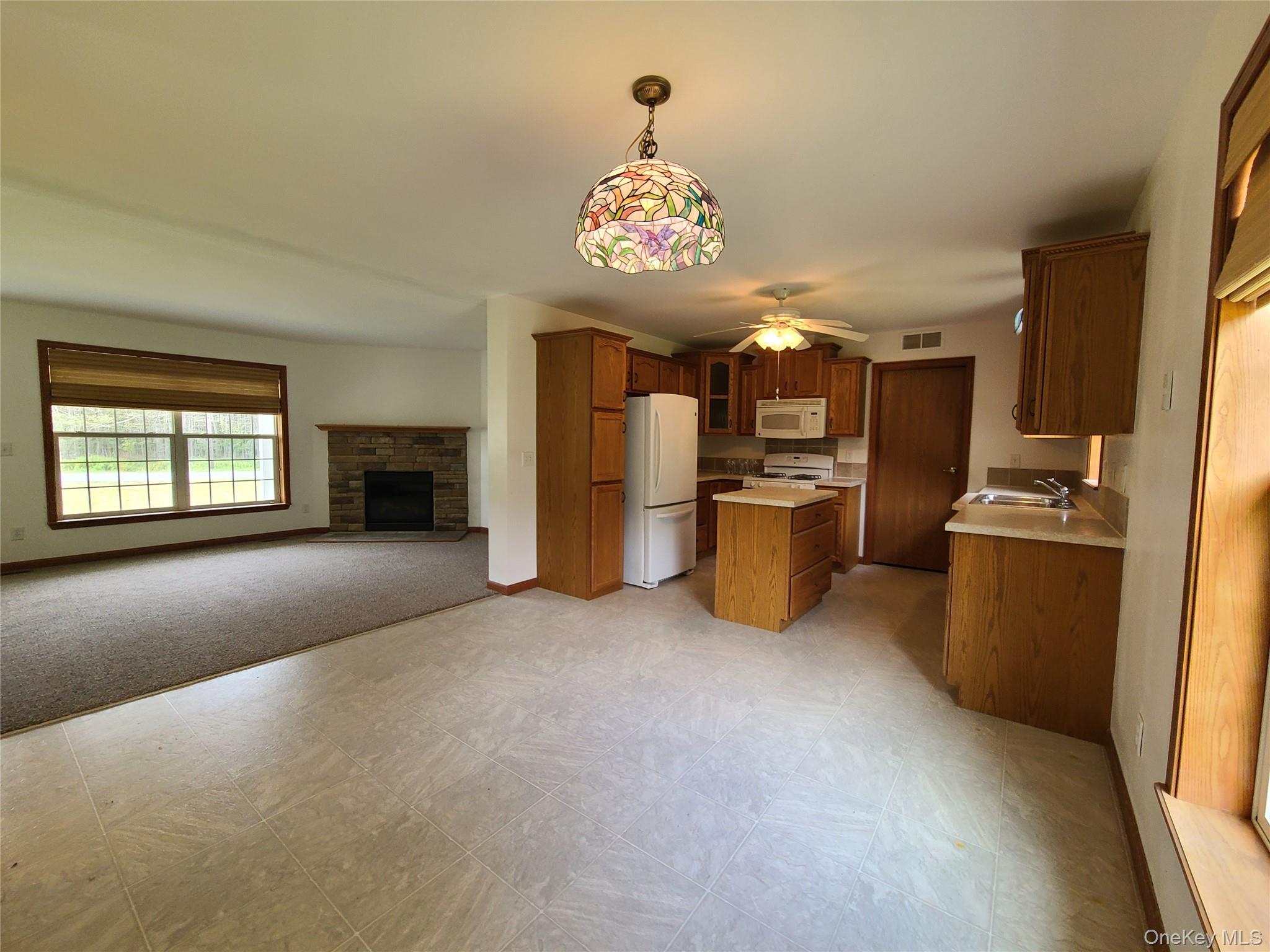 82 Benton Hollow Road Liberty, NY 12754 - Photo 35 of 36 a view of a kitchen with a sink a refrigerator and a fireplace